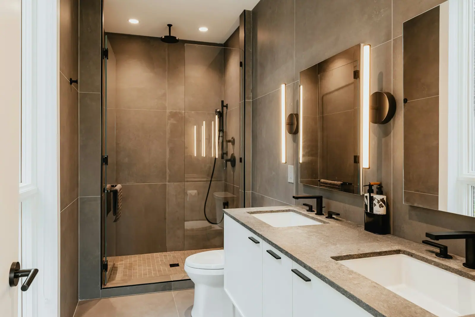 Kahve tonlu seramikli, cam duşakabinli yeni banyo